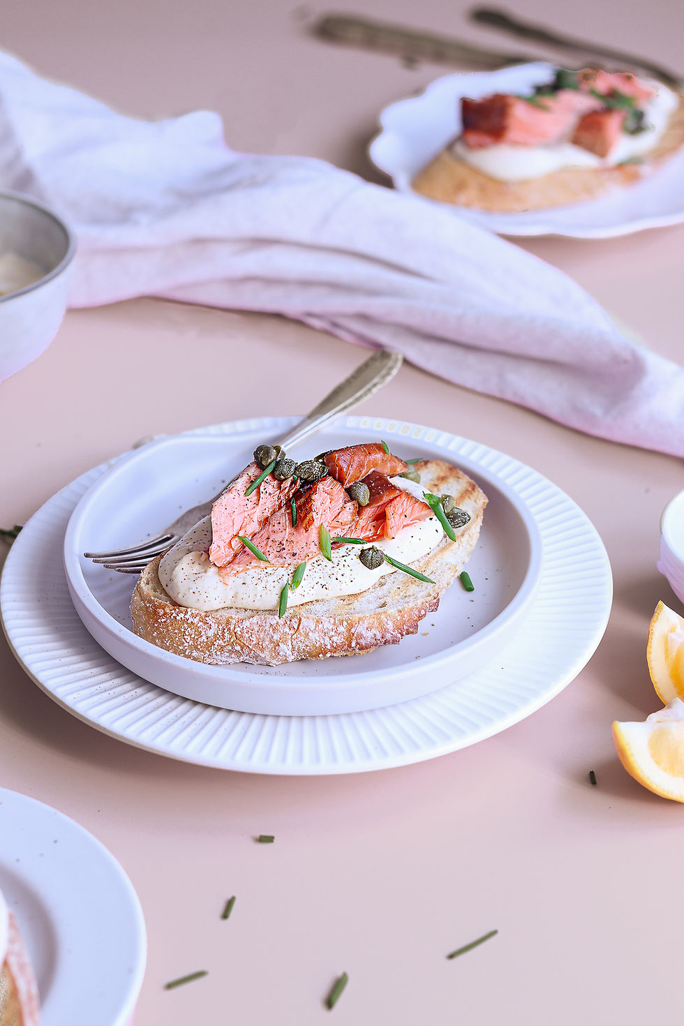 A plate of toast with smoked salmon on a table