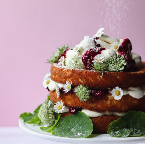A three layer cake filled with cream and decorated with flowers