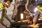 2 metal workers using heavy machinery