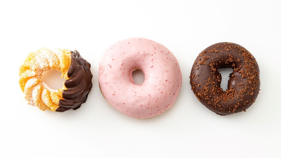 Three assorted donuts with different glazes arranged in a row on a white background