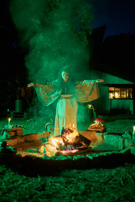 Retrato de mulher de braços abertos envolta em fumaça verde em experiência de fotografia meditativa.