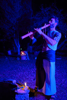Homem tocando flauta em ritual de sound healing e fotografia terapêutica.