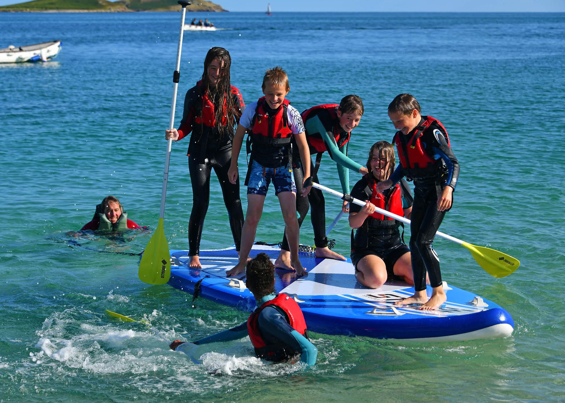 Group of children on a Paddleboard off St Martins Scilly