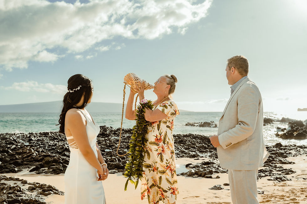 Maui officiant blowing conch shell on the beach of hawaii