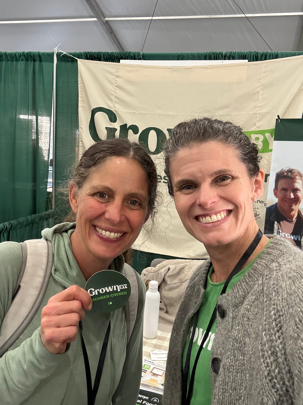 Lindsey Lusher Shute with a farmer holding up a GrownBy farmer-member sticker