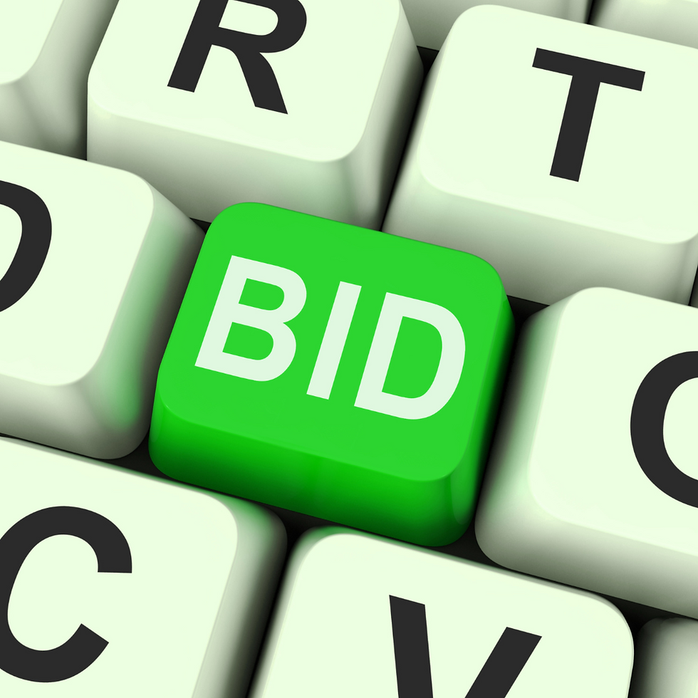 Computer keyboard with 'bid' key highlighted, illustrating online auction process