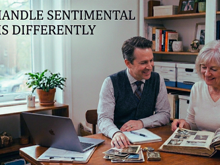 A man and woman smiling at photo album in cozy room. Bookshelf, plants, and "We Handle Sentimental Items Differently" text visible.