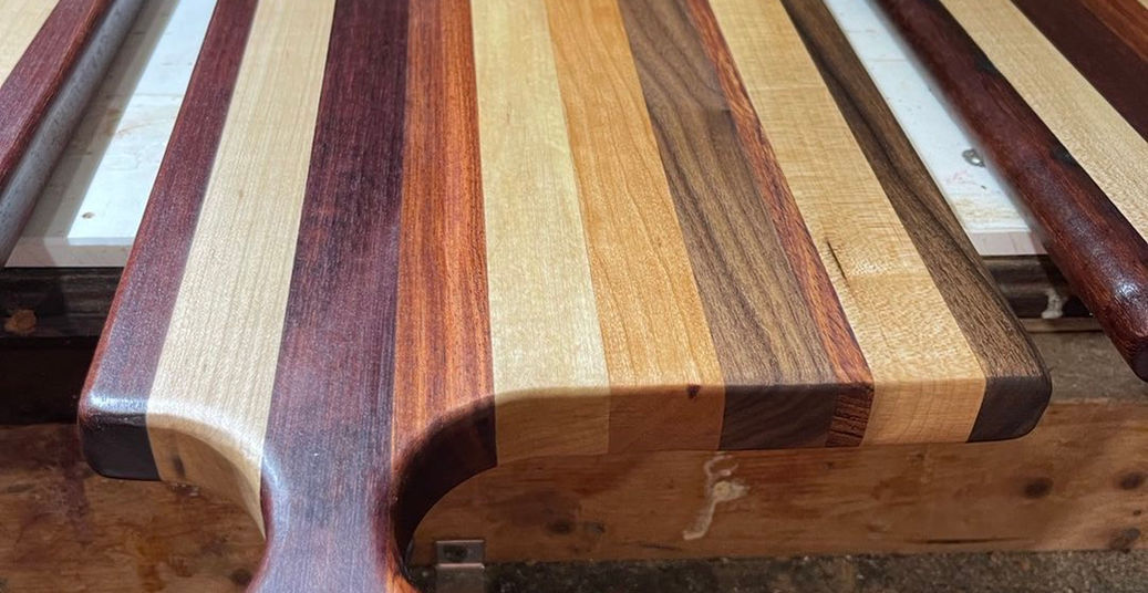 Multi-wood cutting board with handle