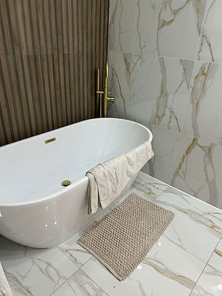 free standing bathtub and tiles with marble effect