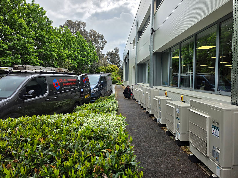 company vans outside a commercial building with air con units