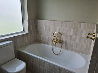 new bathroom fitted with gold taps and shower fitting