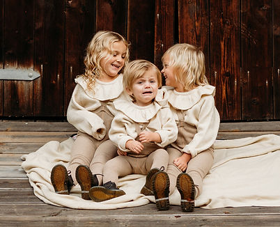 Twins sitting nicely with their little sister