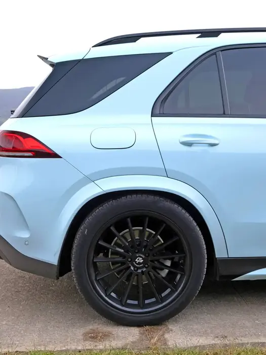 Profilansicht eines Mercedes GLE mit geschwungener Karosserie und getönten Fenstern.