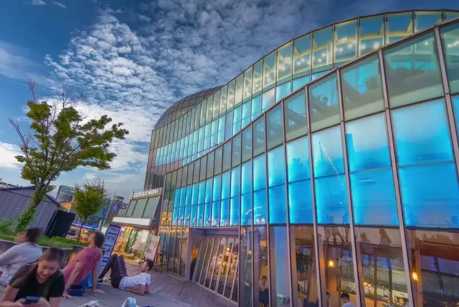 Modern commercial exterior and interior featuring large-scale glass folding doors and curtain walls by EZ FOLD A DOOR, showcasing professional architectural glazing for business environments.