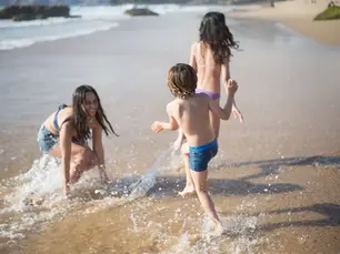 Woman and kids enjoy playing on the beach