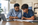 Tutor and student working through a problem together beside a laptop