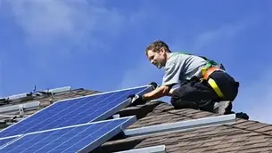 Professional solar installers fitting panels onto residential UK roof