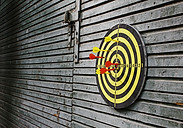 Darts in dartboard on wall