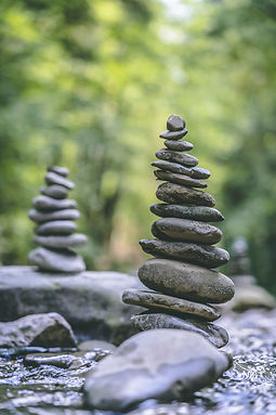 vertical-shot-two-stone-pyramids-balanced-river-water.jpg