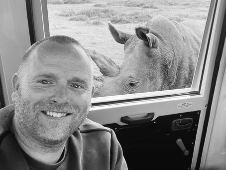 Johan Siggesson in safari vehicle with rhino outside the window