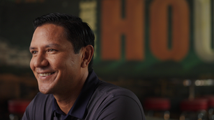 A man smiles to an interviewer off camera
