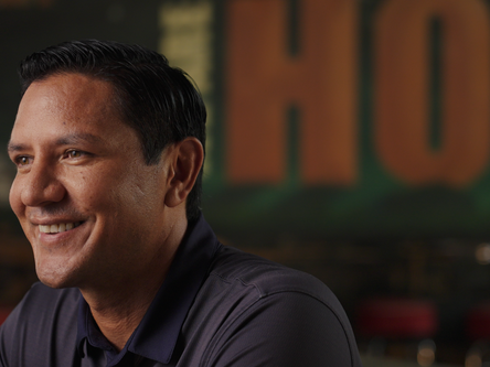 A man smiles to an interviewer off camera