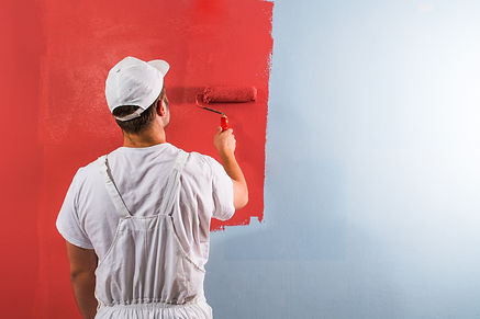 Young man painting wall with roller.jpg