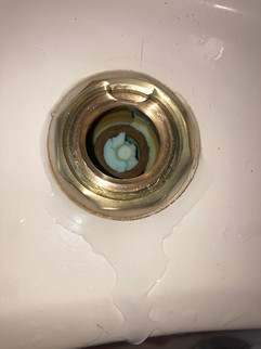 Blocked basin outlet due to deteriorated washer lodged in the breech causing flow restriction