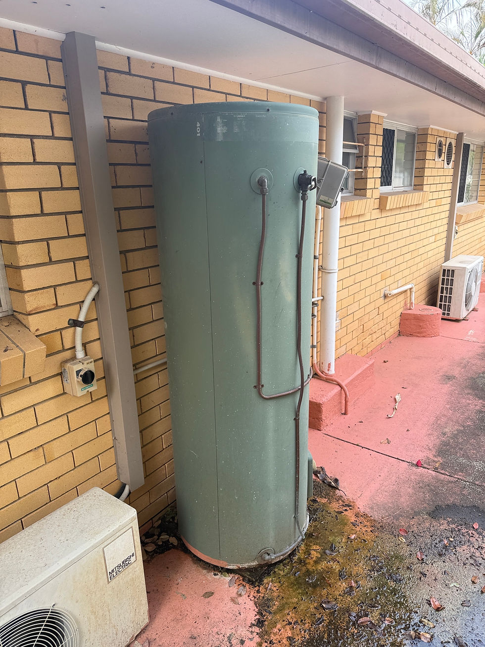 Leaking hot water system with water pooling at base indicating tank failure