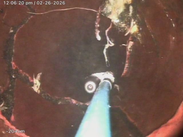CCTV camera inside sewer pipe showing internal damage and buildup