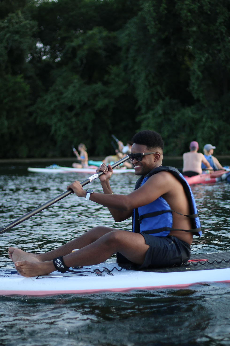 man sitting on stand-up paddleboard (SUP) on Lady Bird Lake in Austin Texas