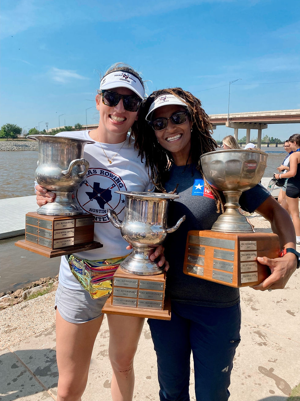 Two female rowers holding championship trophies at race