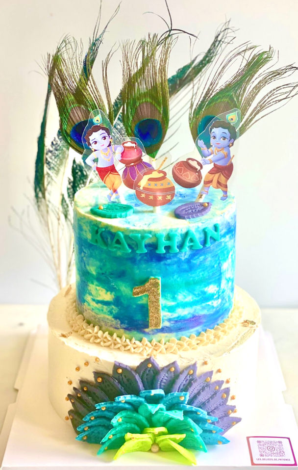Khrisna Colorful birthday cake with fondant peacock feathers, blue and green buttercream, and fantasy decorations.