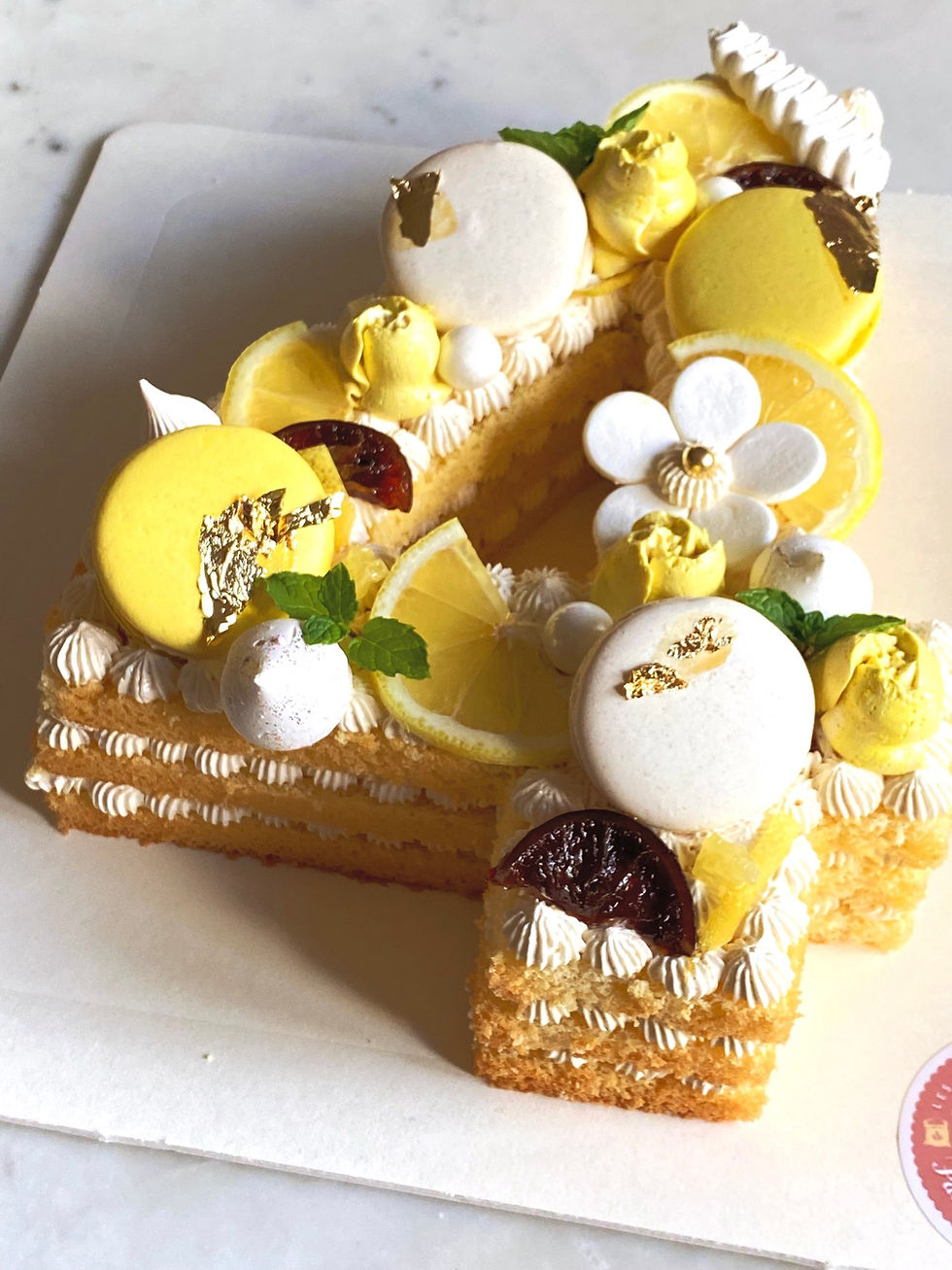 Thumbnail: Number cake 4 — white buttercream with yellow flowers and pearls, soft spring theme.