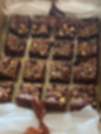 Thumbnail: Brownies arranged on parchment paper with scattered nuts.