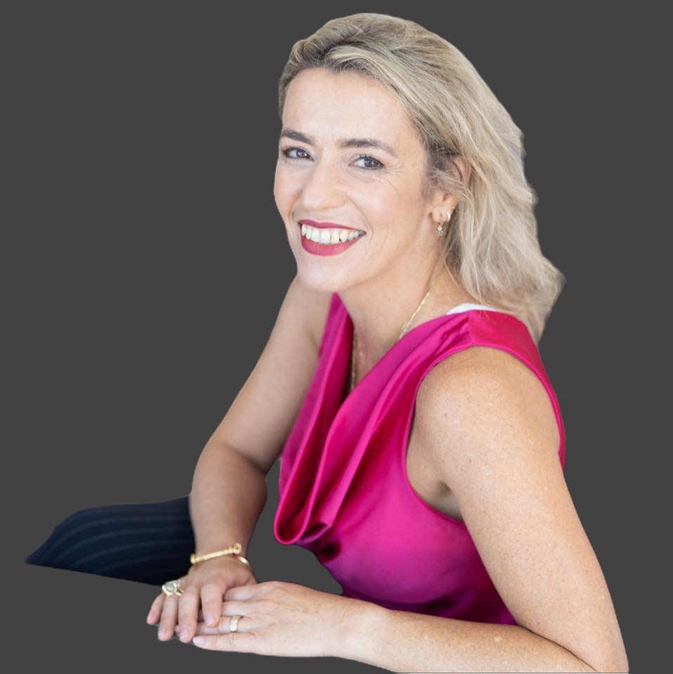 תמונה של אישה לבושה בשמלה ורודה, מחייכת אל המצלמה