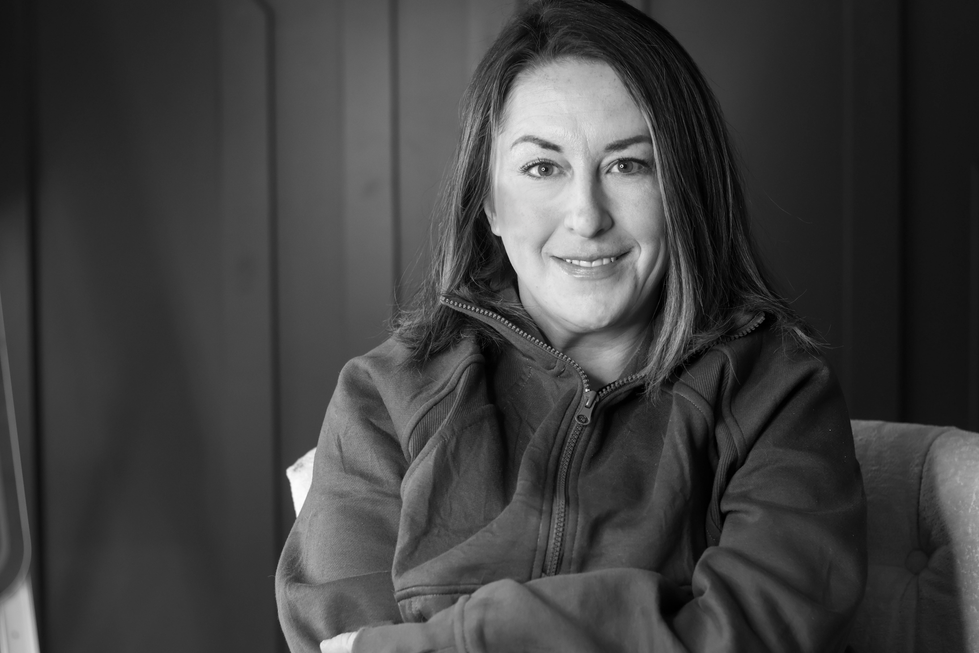 a black and white photo of a woman wearing a grey jacket