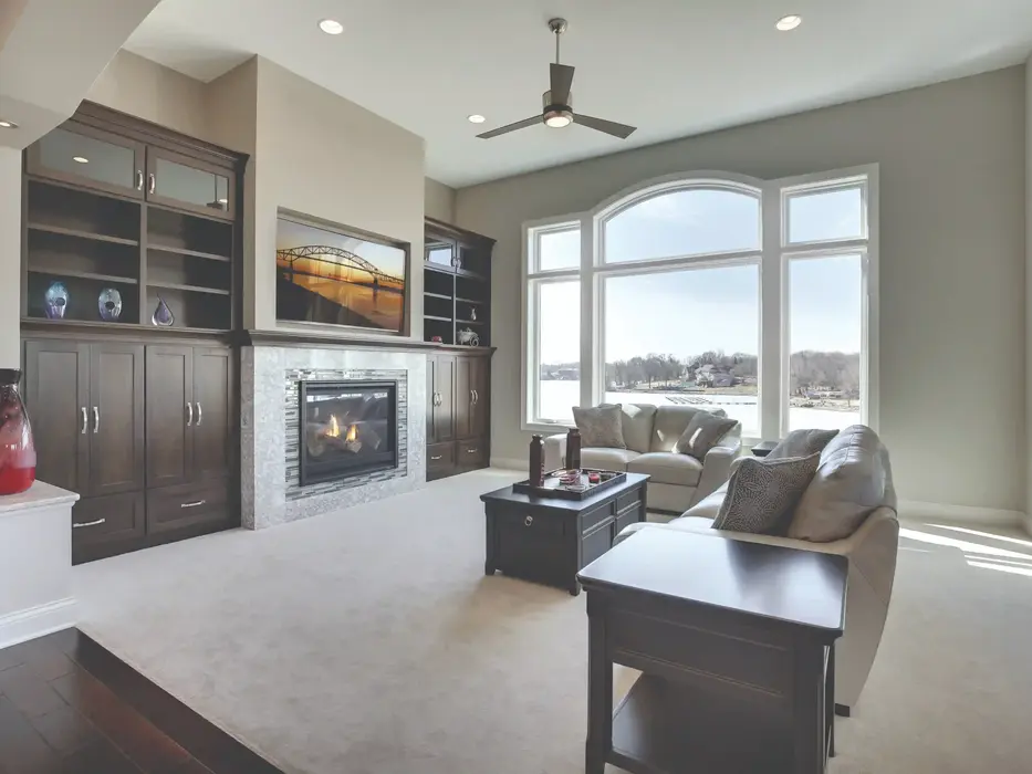Modern living room with fireplace, built-in shelves, and lake view