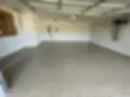 A freshly painted garage floor with a glossy, smooth finish and clean lines, ready for parking and projects.