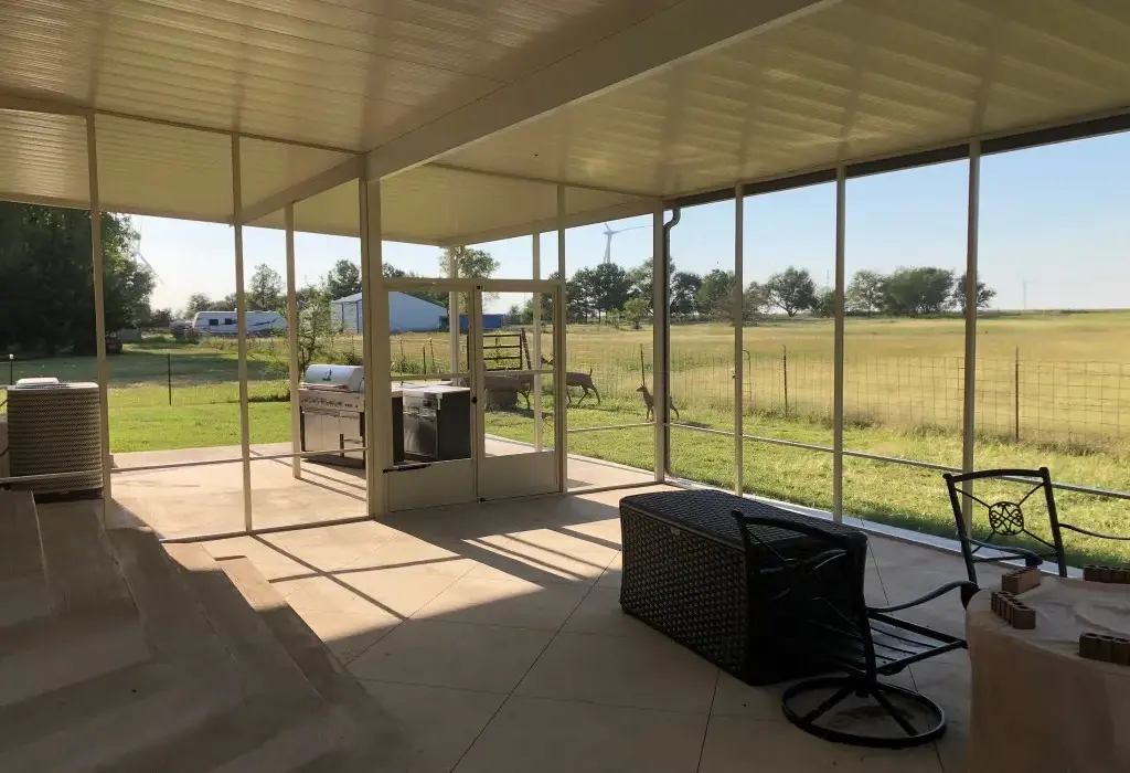 Spacious screened patio enclosure overlooking a rural landscape