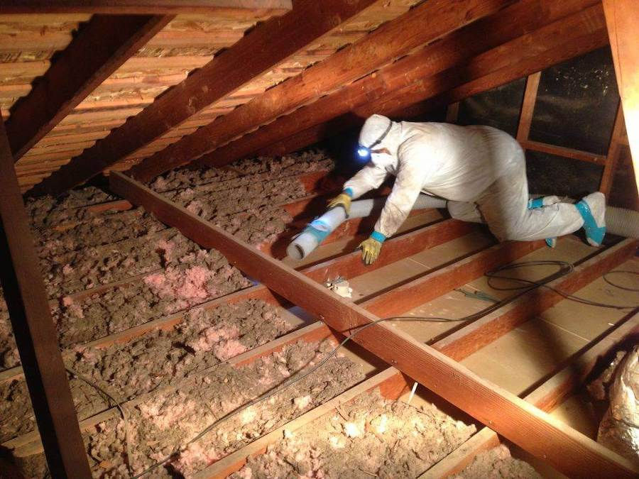 Technician installing attic insulation