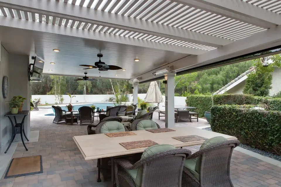 Covered patio furniture with ceiling fan, near pool