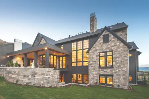 Modern stone house with large windows at dusk