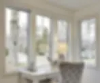 Bright home office with large windows showcasing a tree and parked cars