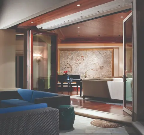 Modern home interior with folding glass doors, opening to patio