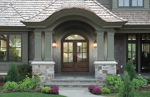 Elegant arched double door entrance to home 3285, stone accents