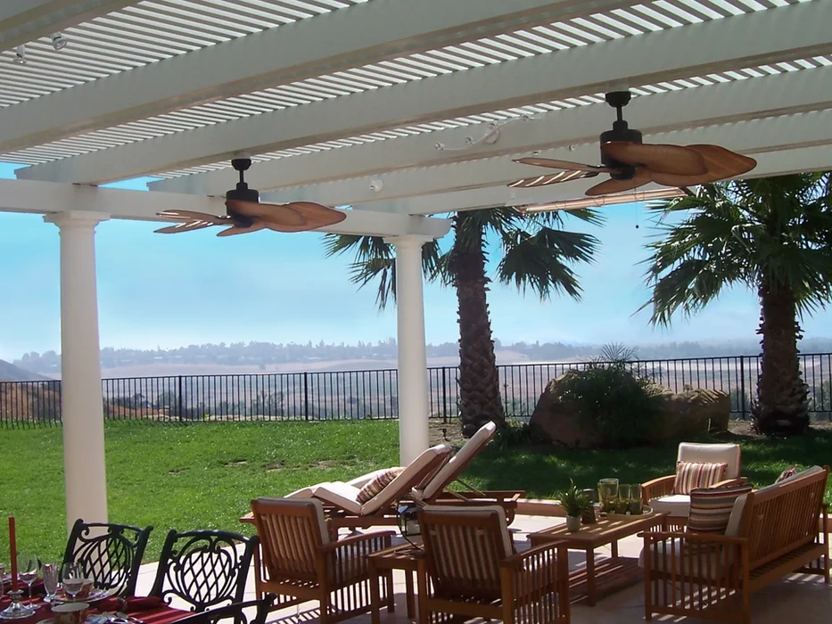Relaxing patio with ceiling fans, wooden furniture, and scenic view