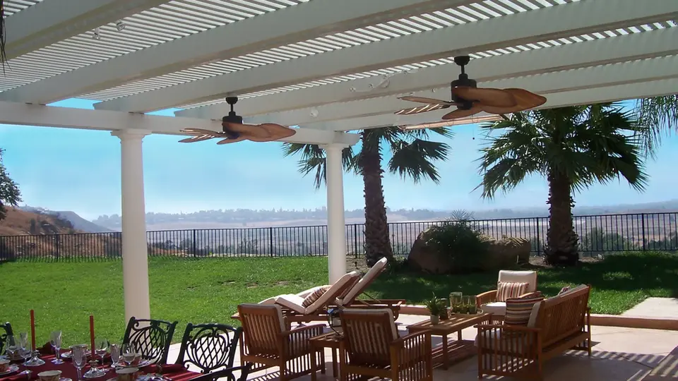 Relaxing patio with ceiling fans, wooden furniture, and scenic view