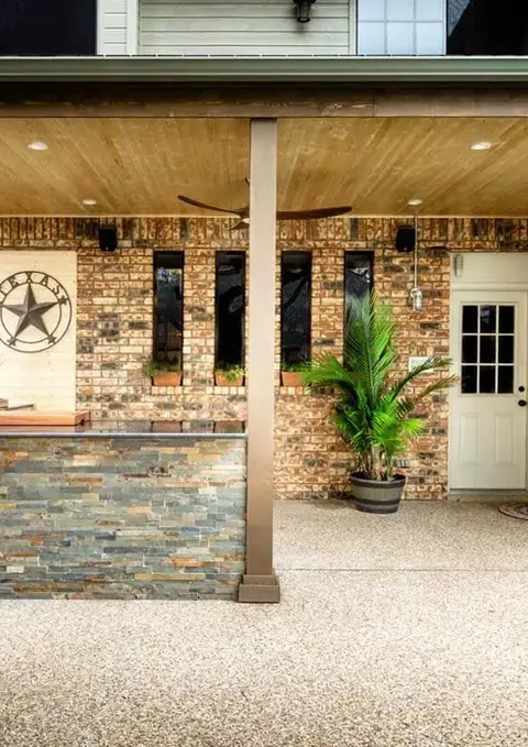 Outdoor kitchen with Texas star, brick walls, and ceiling fan