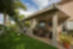 Covered patio furniture with a grassy backyard